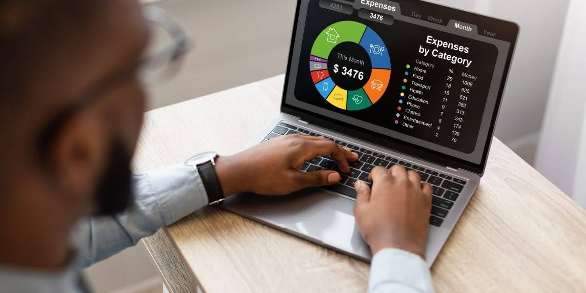 A business owner analyzing a digital dashboard on a laptop that categorizes and displays tracking business expenses by category.